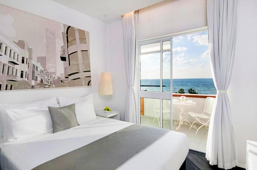 a bedroom with a bed and a view of the ocean at Olive Gordon By The Beach in Tel Aviv