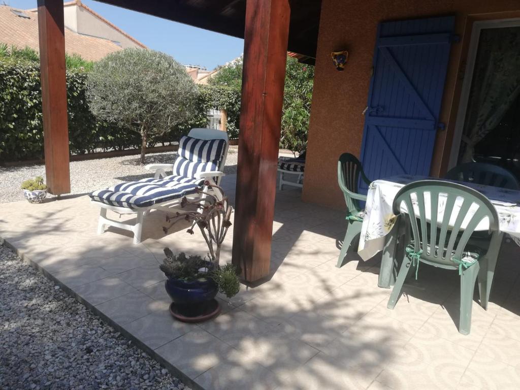 two chairs and a table on a patio at MARINES DU ROUSSILLON 78 - EN RESIDENCE AVEC PISCINE PROCHE PLAGE in Saint-Cyprien