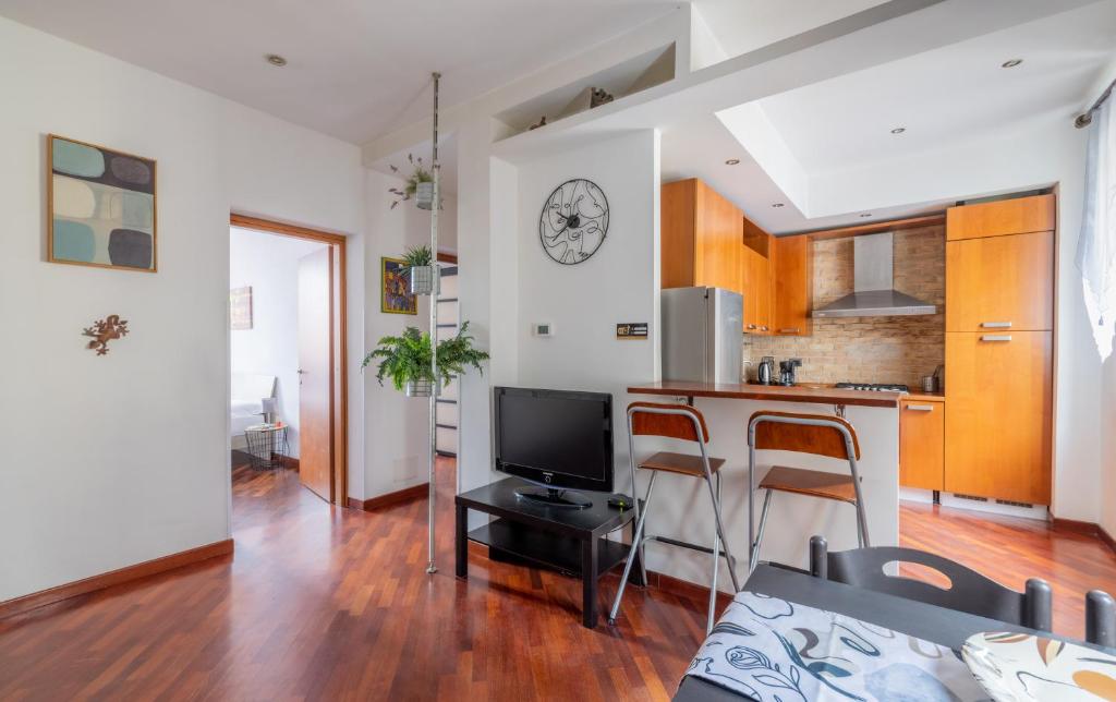 eine Küche und ein Wohnzimmer mit einer Theke und einem TV in der Unterkunft Smart Lodging Downtown in Rom
