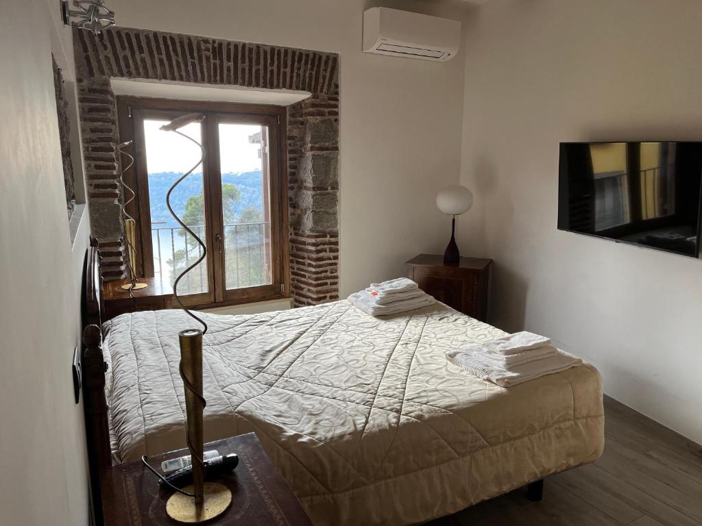 a bedroom with a bed and a window at Albergo Diffuso Locanda Specchio Di Diana in Nemi