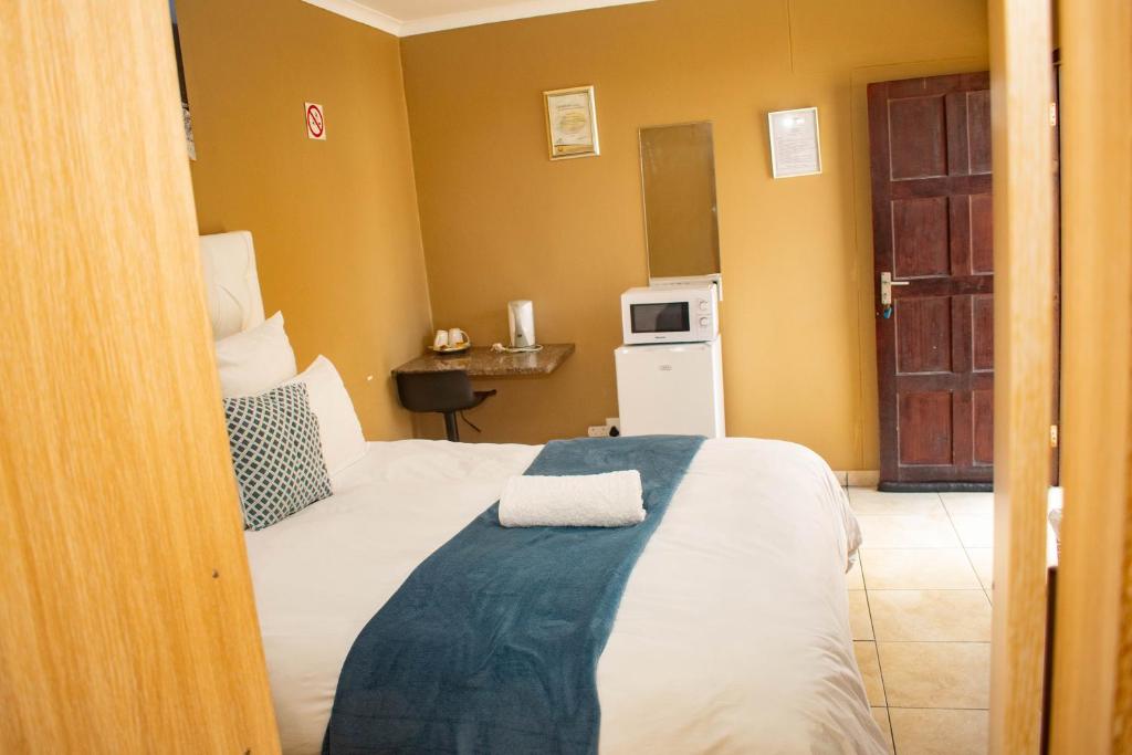 - une chambre avec un lit et une serviette dans l'établissement Josef Self Catering, à Swakopmund