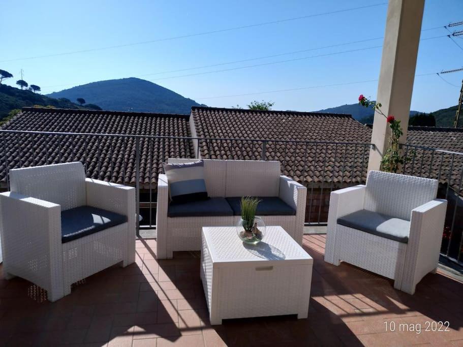 a patio with two chairs and a table on a roof at La casa accanto in Rio nellʼElba