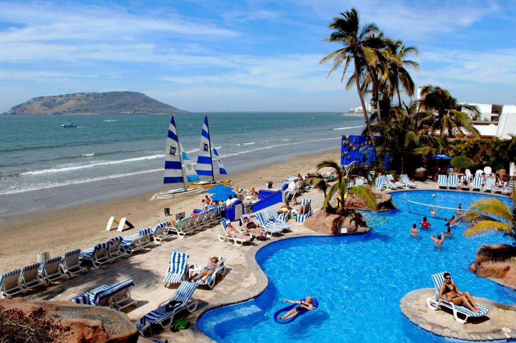 a view of a beach with a swimming pool and the ocean at Royal Villas Resort in Mazatlán