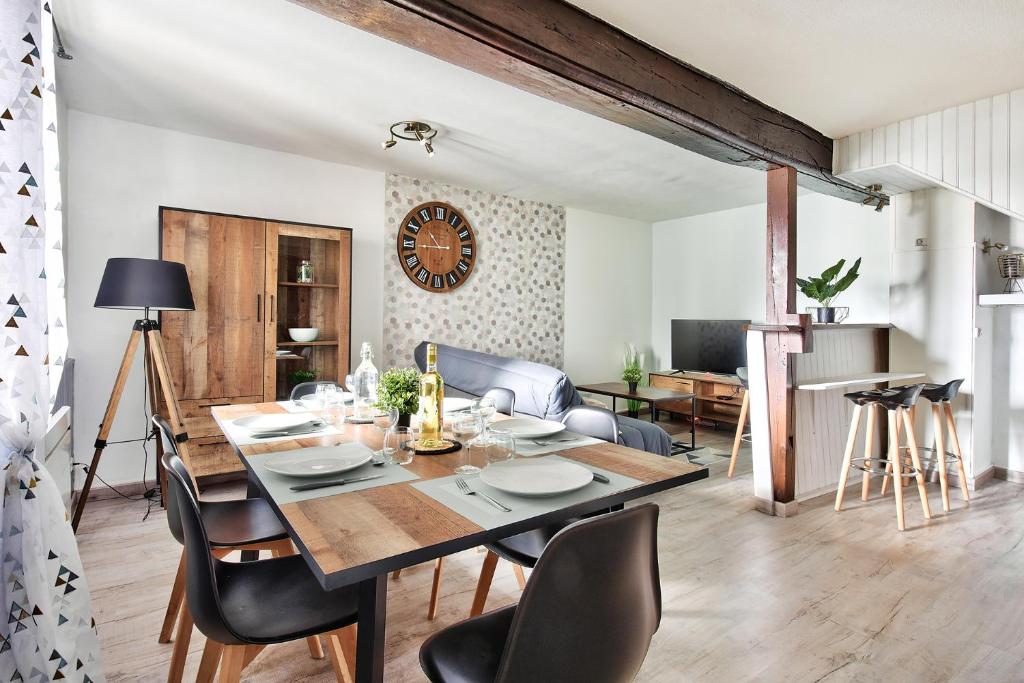 uma sala de jantar e sala de estar com mesa e cadeiras em Appartement Le Spacieux Bressan - Hyper-Centre em Bourg-en-Bresse