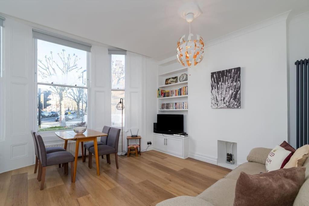 ein Wohnzimmer mit einem Tisch und einem Sofa in der Unterkunft GuestReady - New and spacious near BBC Maida Vale in London