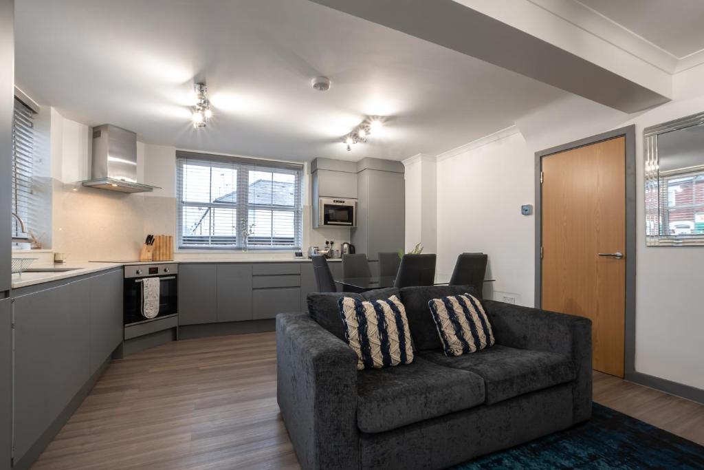 a living room with a couch and a kitchen at Bedford Road in Reading