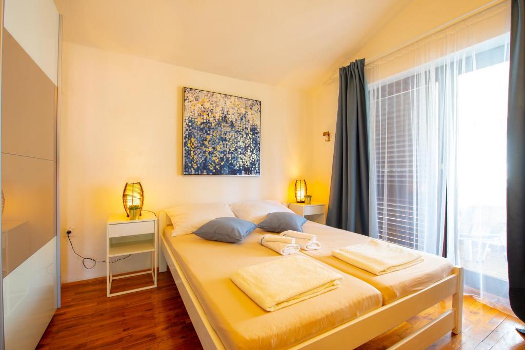 1 dormitorio con 1 cama con 2 toallas en Apartments Ela en Novalja