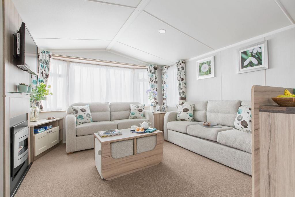 ein Wohnzimmer mit einem Sofa und einem Tisch in der Unterkunft 56 Seabreeze in Milford on Sea