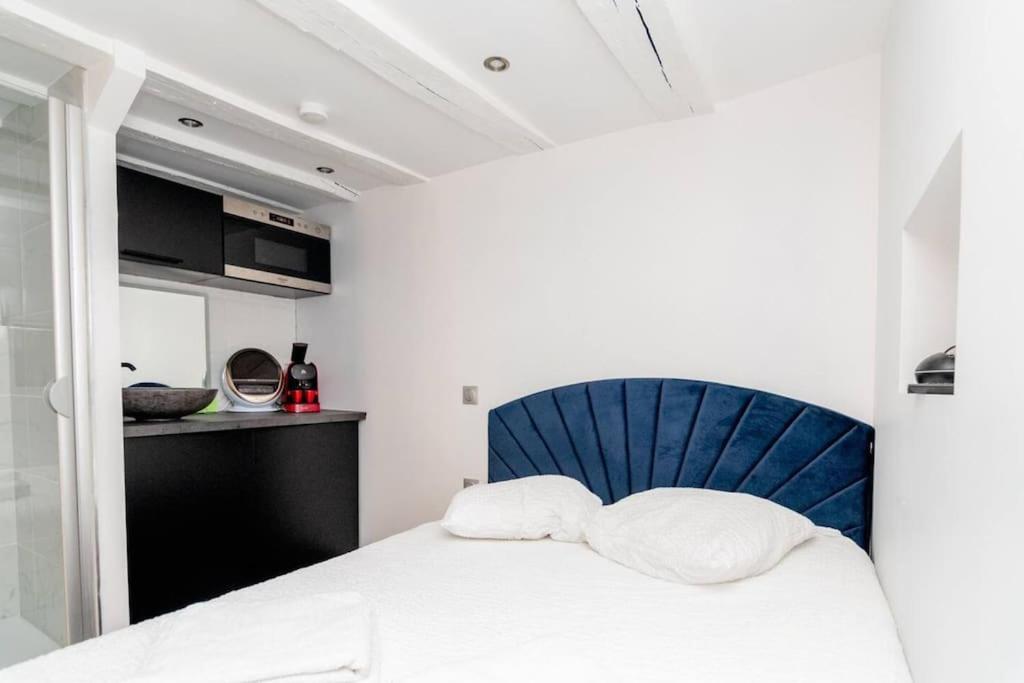 ein Schlafzimmer mit einem Bett mit einem blauen Stuhl in der Unterkunft Studio balnéo - Centre-ville in Chalon-sur-Saône
