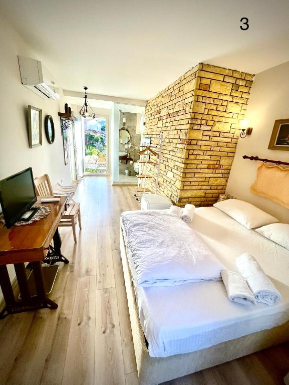 a bedroom with a large bed with a brick wall at Destina Hotel in Çeşme
