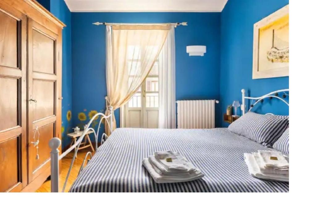 トリノにあるLa casa dei pescatoriの青い壁のベッドルーム1室、ベッド1台(タオル付)