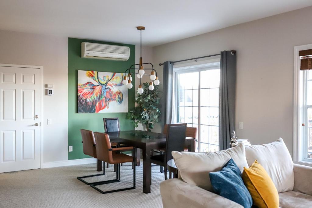 a living room with a table and a couch at Plage et piscine au Mont Blanc in Saint-Faustin