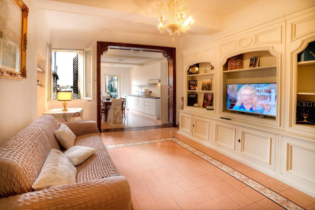 ein Wohnzimmer mit einem Sofa und einem TV in der Unterkunft Dama charming apartment 100m from Piazza del Campo in Siena