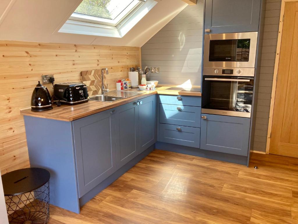 a kitchen with blue cabinets and a skylight at Laity's Lodge in Penzance