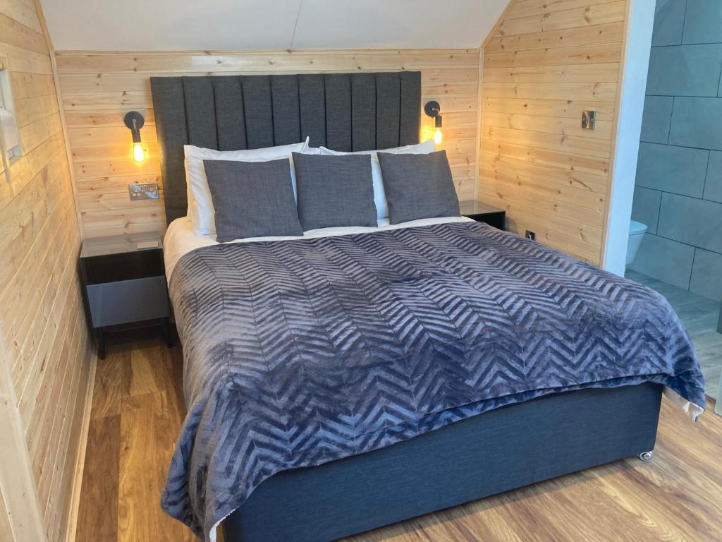 a bedroom with a bed with a blue and gray comforter at Laity's Lodge in Penzance