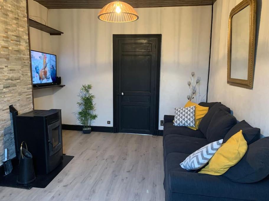 a living room with a blue couch and a black door at Gîte de Lafayette in Pionsat