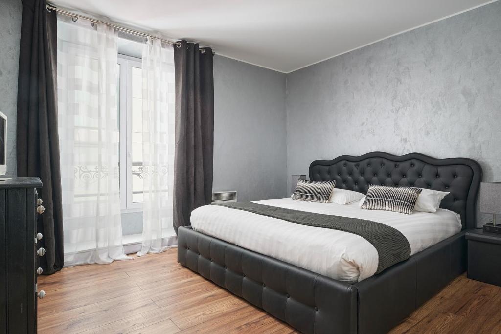 a bedroom with a large bed and a large window at Apparthotel des Congrès et Festivals in Cannes