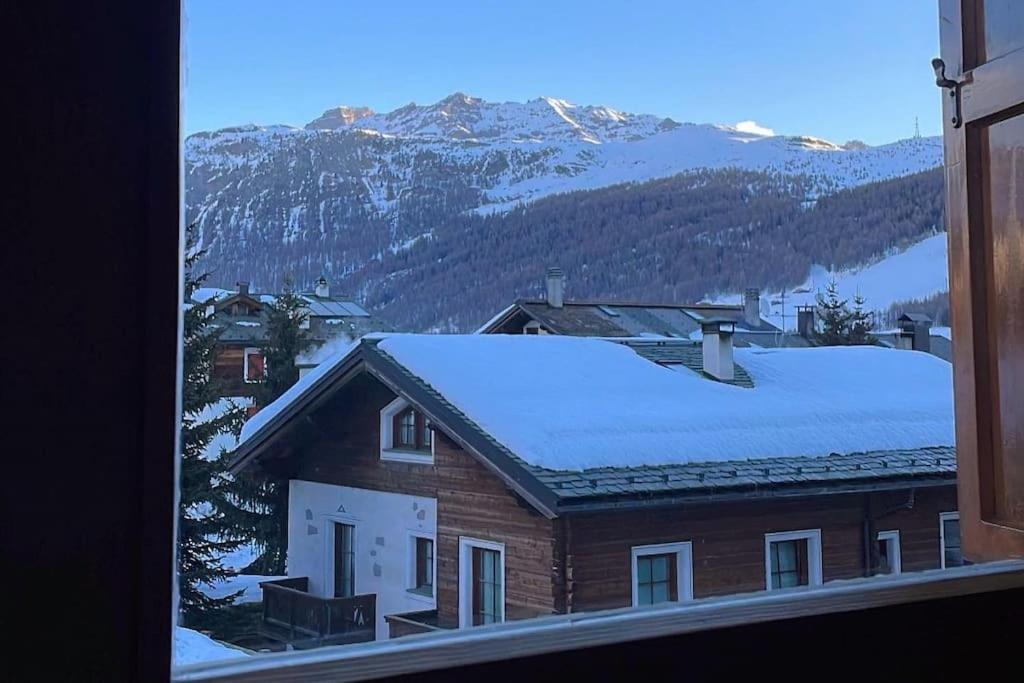 uma vista para uma casa com neve no telhado em Appartamento Rin, Livigno em Livigno