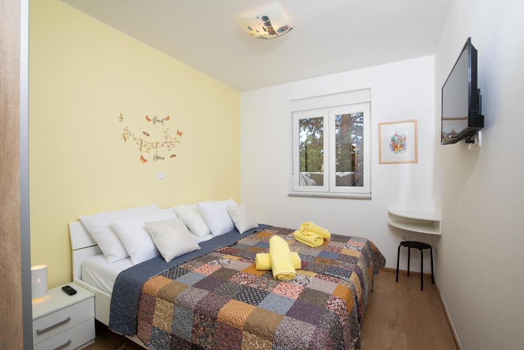 sypialnia z łóżkiem z żółtą kaczką w obiekcie Apartment J&E w Medulinie