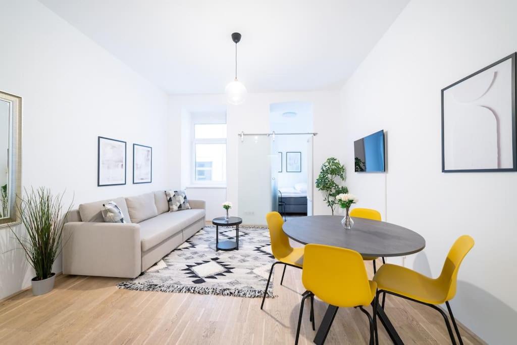 a living room with a table and yellow chairs at Beautiful apartment in Vienna's heart 1b in Vienna