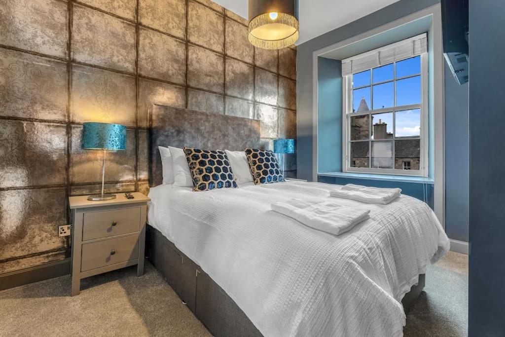 Un dormitorio con una cama grande y una ventana en Boutique Modern Royal Mile Apartment Sleeps 4, en Edimburgo