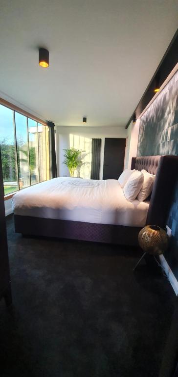 a bedroom with a large bed with a large window at Contemporary Dublin Airport Lodge in Lispapple Cross Roads