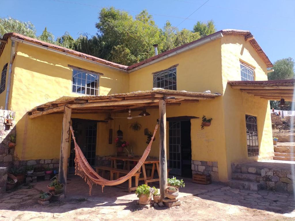a yellow house with a hammock in front of it at La Amarilla, casa con hermosa vista in Tilcara