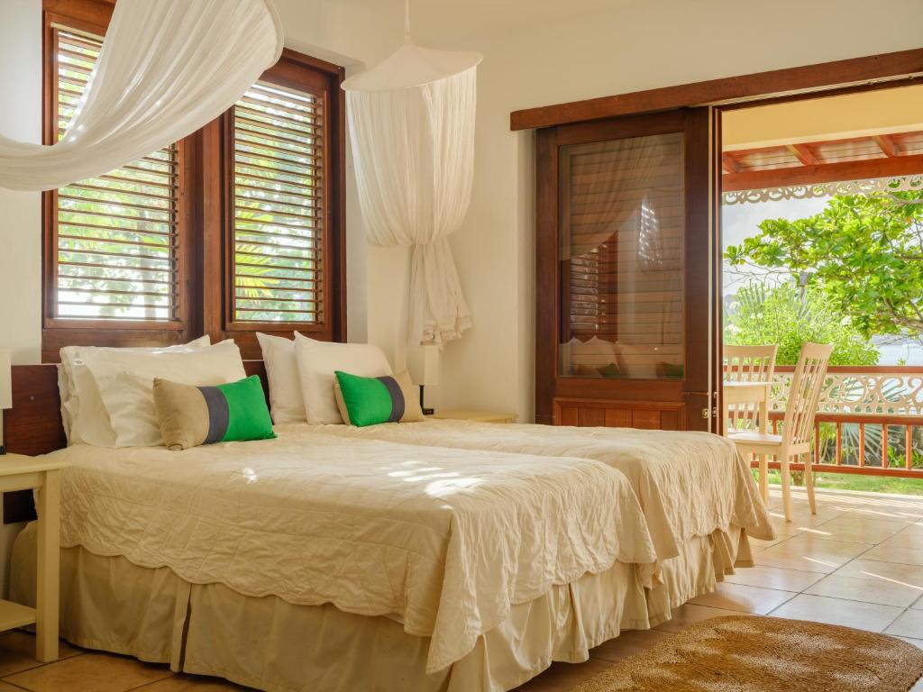 a bedroom with a large bed and a balcony at Gingerbread Suites in Port Elizabeth