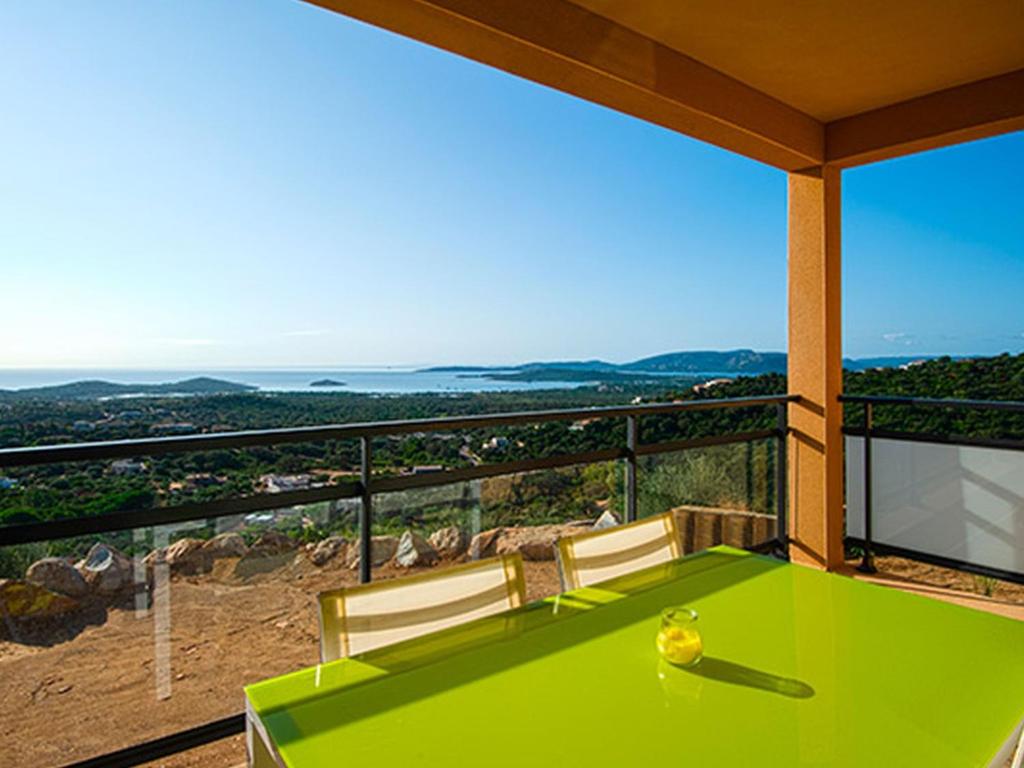 una mesa verde y sillas en un balcón con vistas en Apartment T3 premium vue mer by Interhome, en Zonza