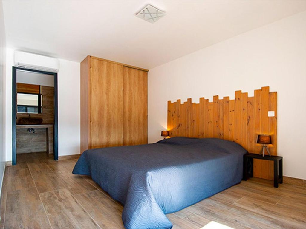 1 dormitorio con 1 cama con cabecero de madera en Apartment T3 premium vue mer by Interhome, en Zonza