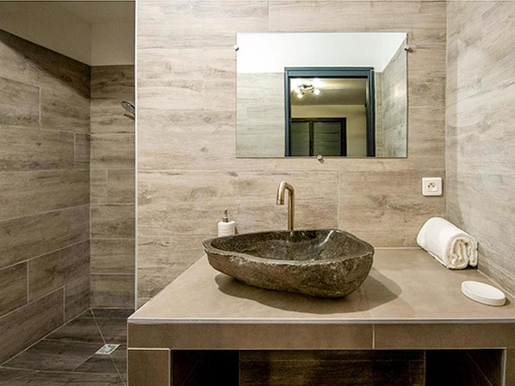 y baño con lavabo de piedra y espejo. en Apartment T3 premium vue mer by Interhome, en Zonza