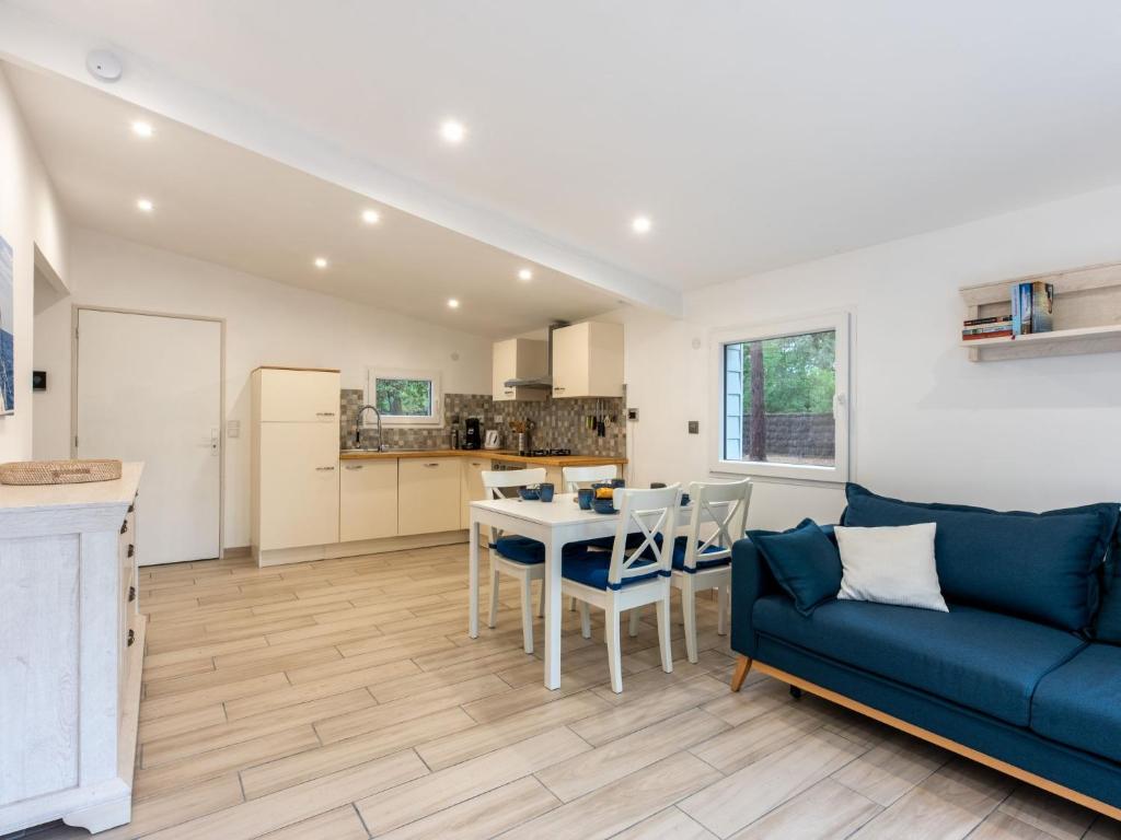 Una sala de estar con un sofá azul y una mesa. en Chalet Cottage Etoile de mer by Interhome, en Lacanau