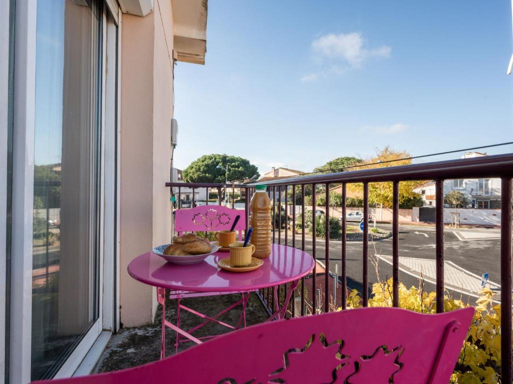 een roze tafel met een kom eten op een balkon bij Apartment Etoile de Mer by Interhome in Canet-en-Roussillon