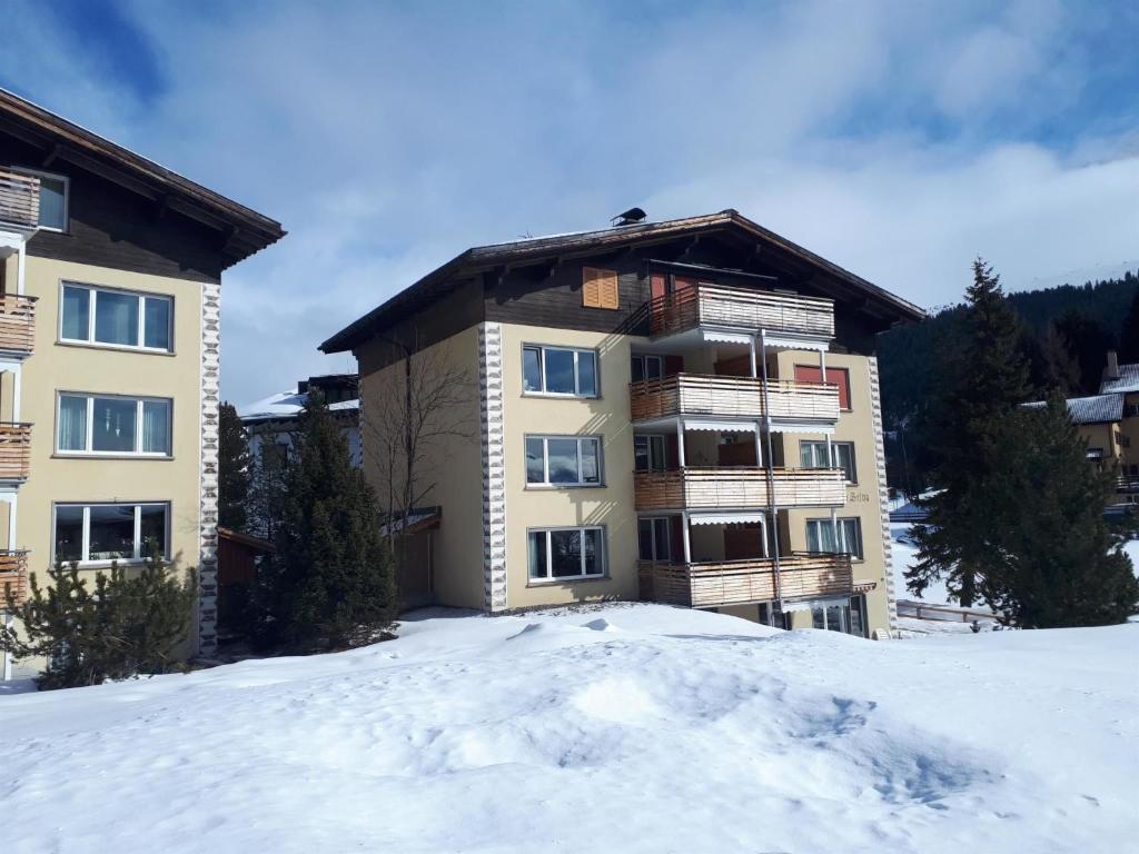 un edificio de apartamentos en la nieve en las montañas en Apartment Casa Selva Hauggaard by Interhome, en Valbella
