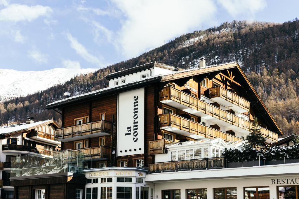 a large building with a mountain in the background at la couronne Hotel & Spa in Zermatt