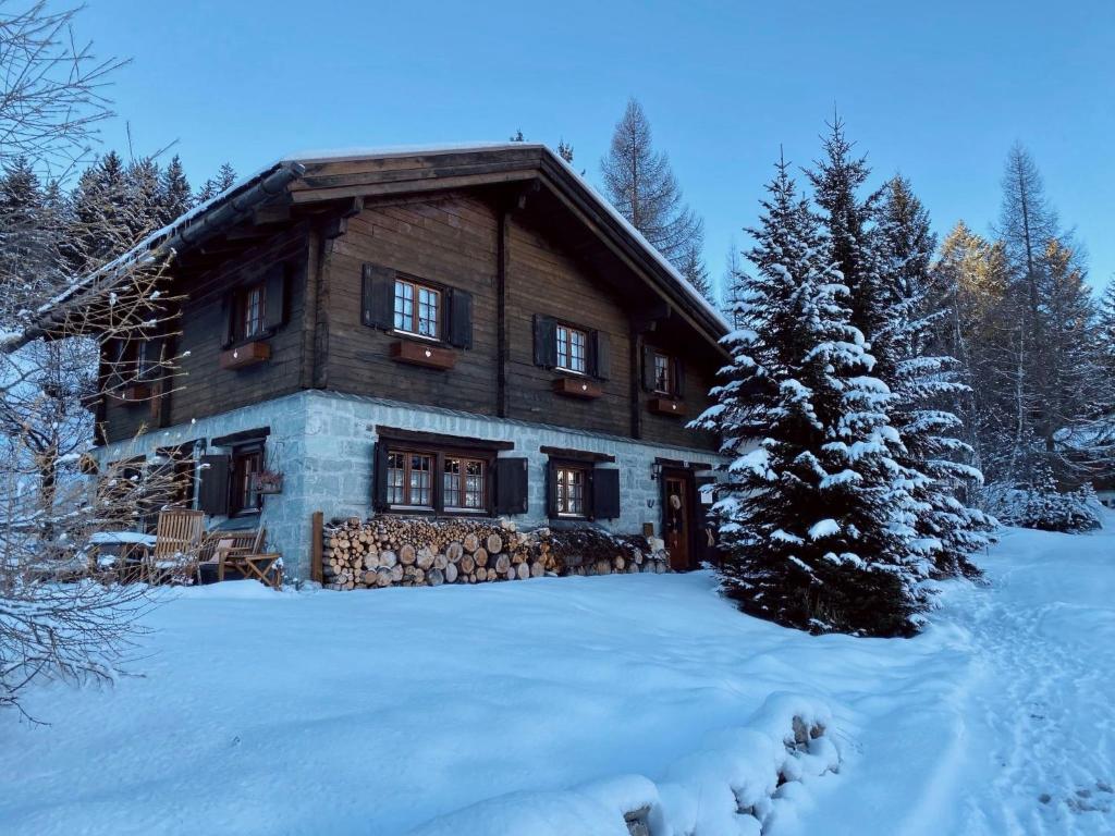 a log cabin in the snow with a christmas tree at Chalet Chalet Rodas 9 by Interhome in Malmigiuer