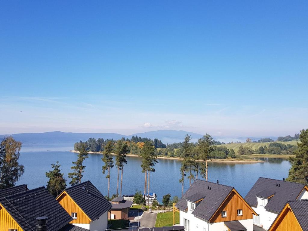 a view of a lake with houses and trees at Holiday Home Lakeside Village 40 by Interhome in Frymburk