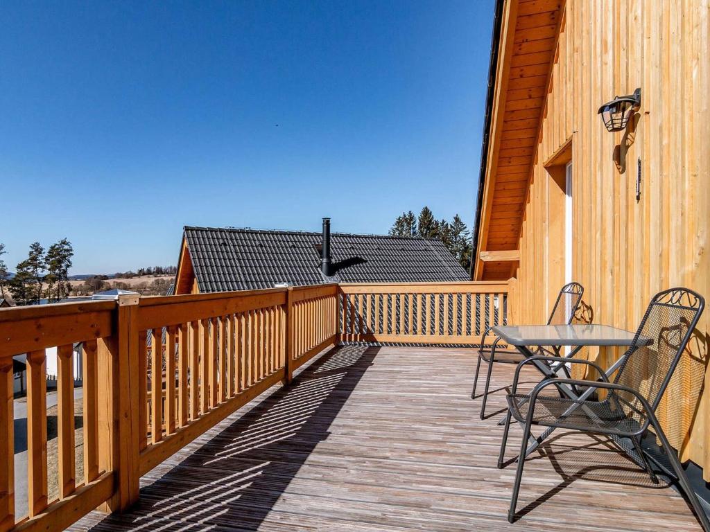 a wooden deck with two chairs and a table on it at Holiday Home Lakeside Village 35 by Interhome in Frymburk
