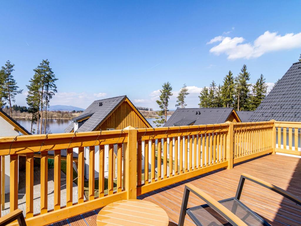 a wooden deck with chairs and a view of a lake at Holiday Home Lakeside Village 22 - - sauna by Interhome in Frymburk