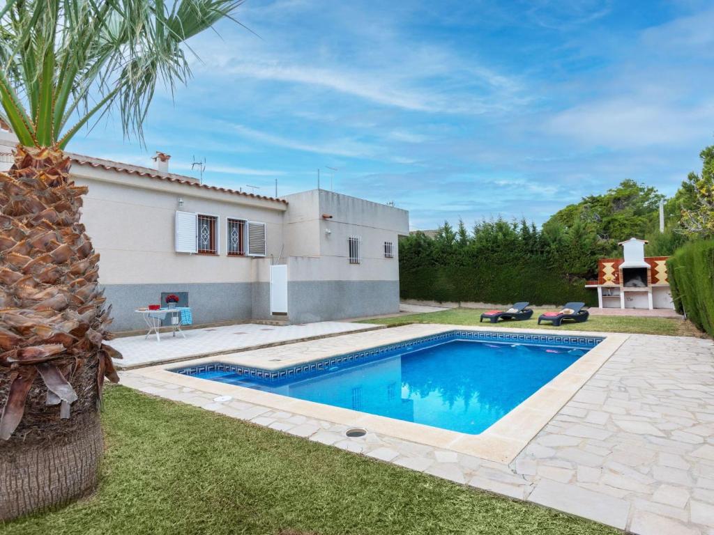 a villa with a swimming pool in front of a house at Villa Villa Tello by Interhome in L'Ametlla de Mar
