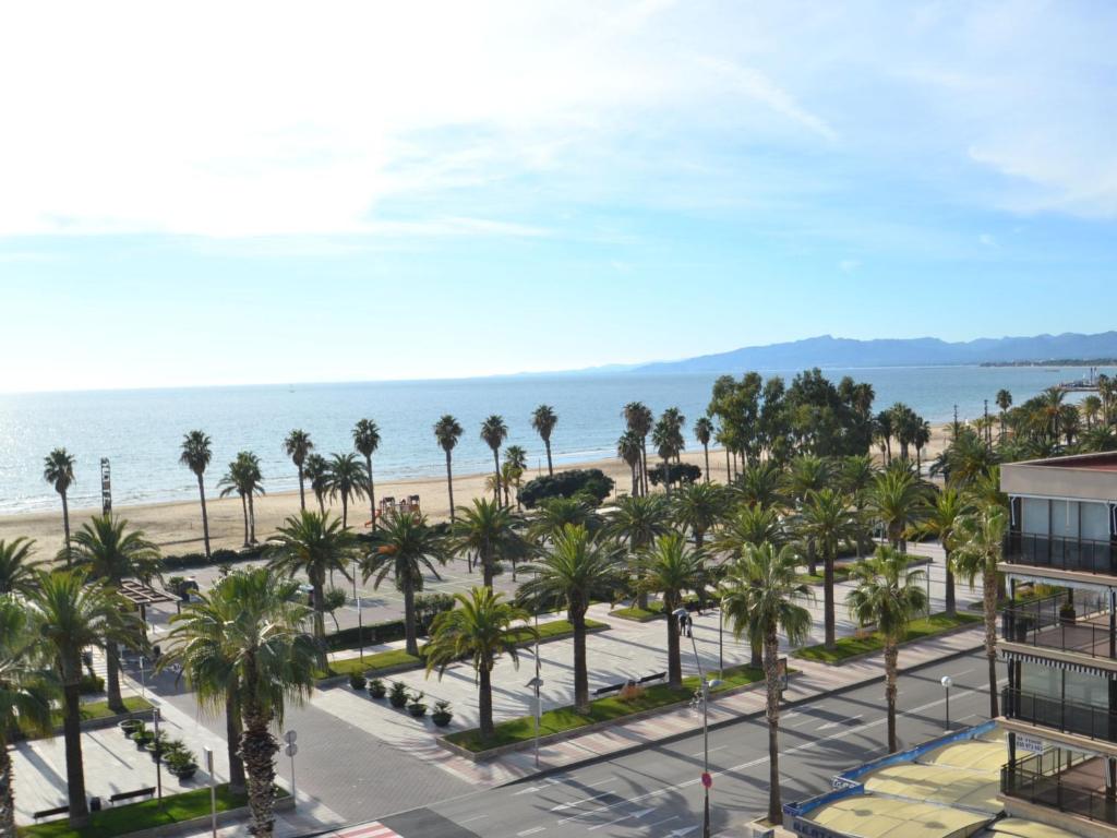 a view of the beach and palm trees from a building at Apartment Formentor by Interhome in Salou