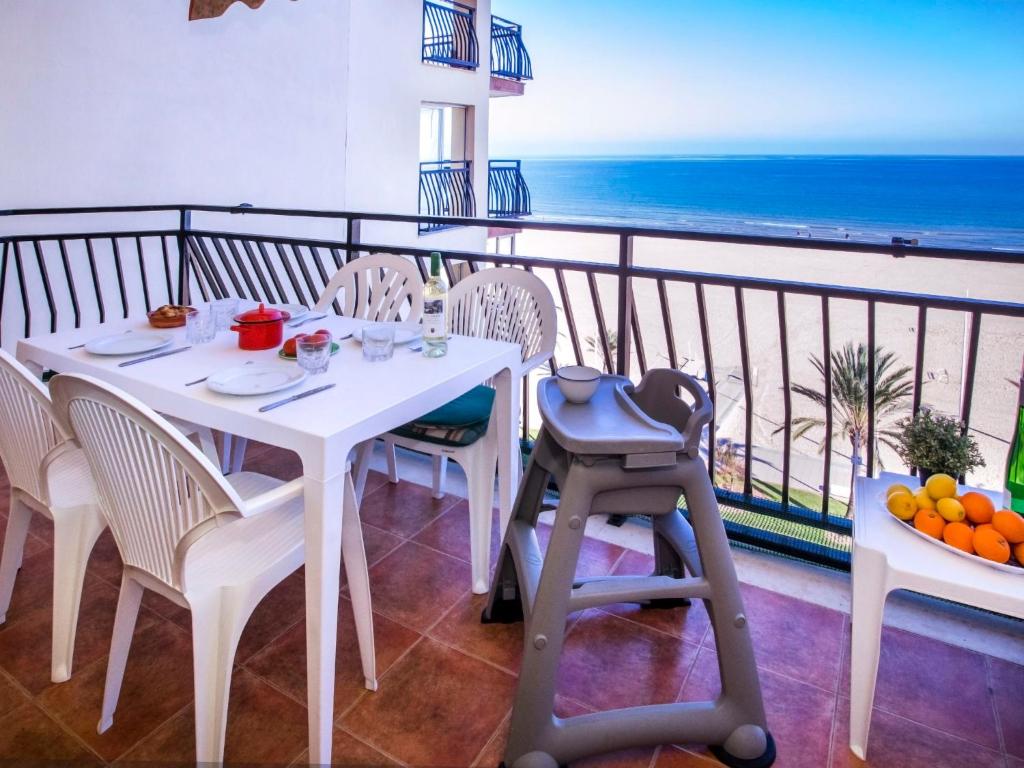 een witte tafel en stoelen op een balkon met uitzicht op de oceaan bij Apartment Ondina Plus by Interhome in Playa de Gandia