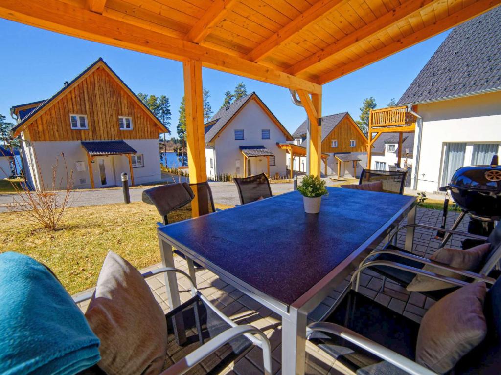 a large patio with a blue table and chairs at Holiday Home Lakeside Village 23 - - sauna by Interhome in Frymburk