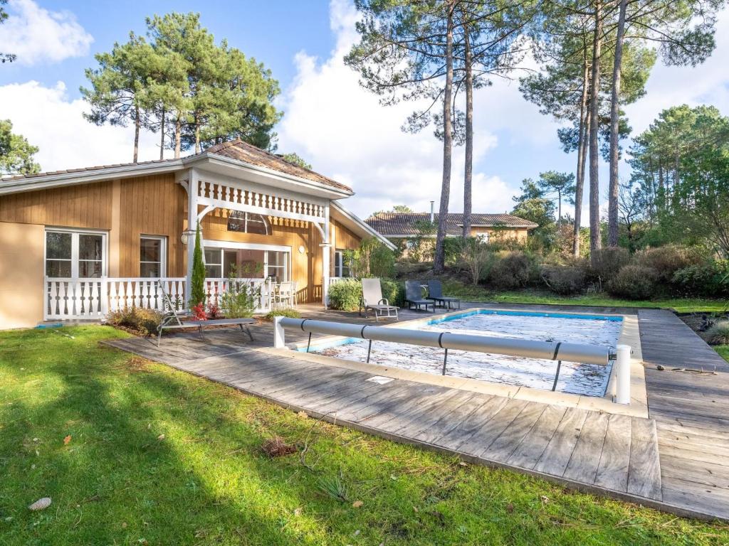 une maison avec une piscine et une terrasse en bois dans l'établissement Holiday Home Atlantic Green by Interhome, à Lacanau-Océan