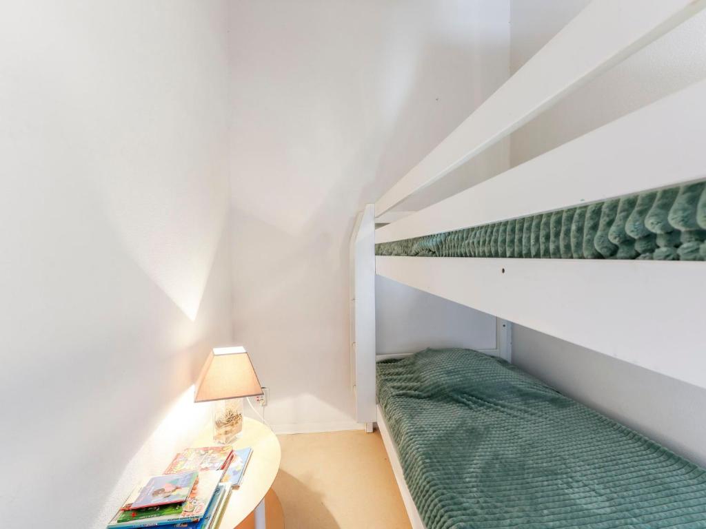 a small room with a bunk bed and a lamp at Apartment Eden Roc 2 by Interhome in Narbonne-Plage