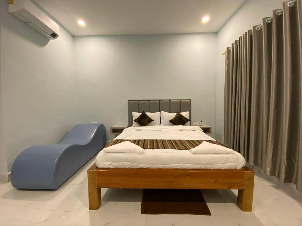 um quarto com uma cama e uma cadeira azul em 83 Guesthouse em Bahal