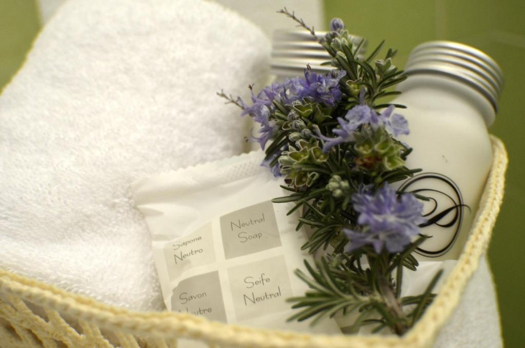 a basket with a bottle of soap and purple flowers at Masseria Asciano in Ostuni