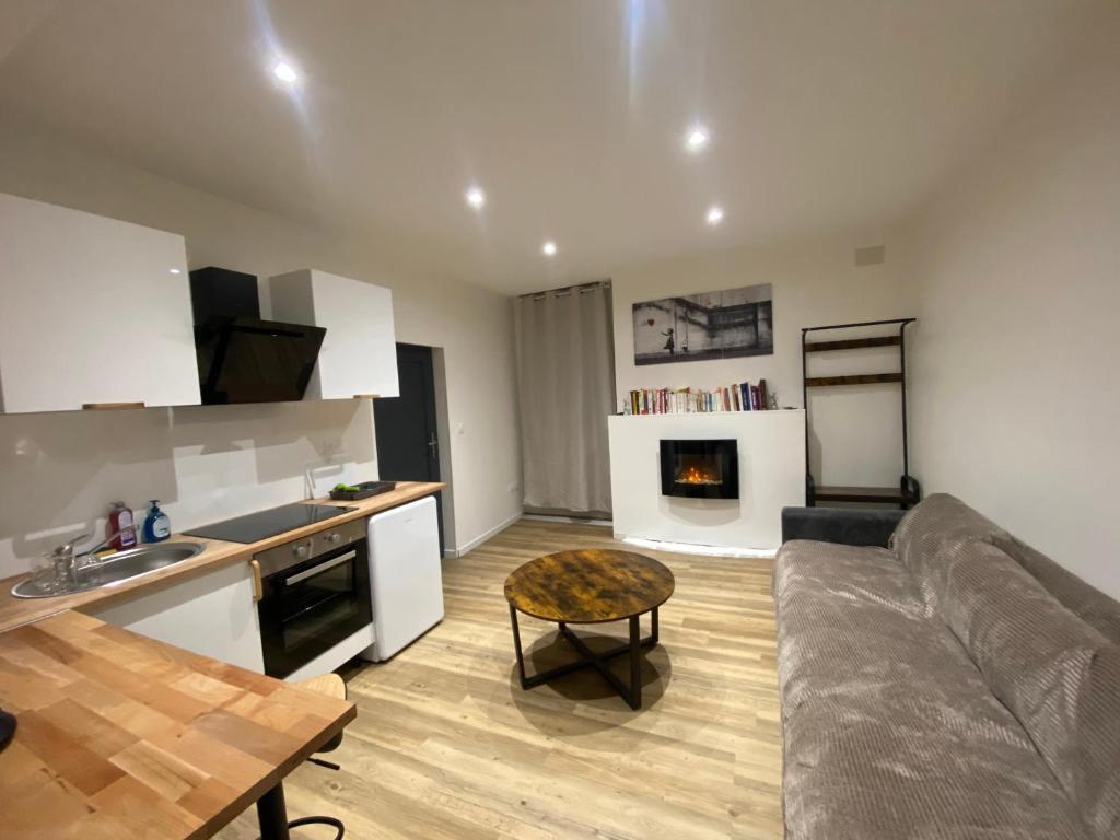 a kitchen and living room with a couch and a table at Le puits du bourg in Nevers