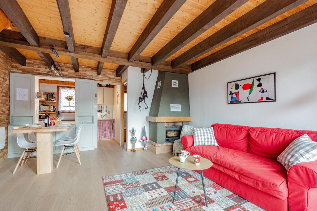 a living room with a red couch and a table at Kioné - duplex avec terrasse in La Bresse