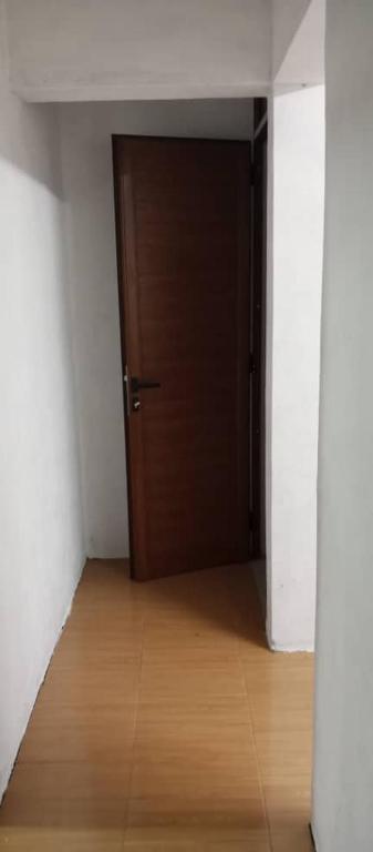 a hallway with a brown door and a wooden floor at rashitta 